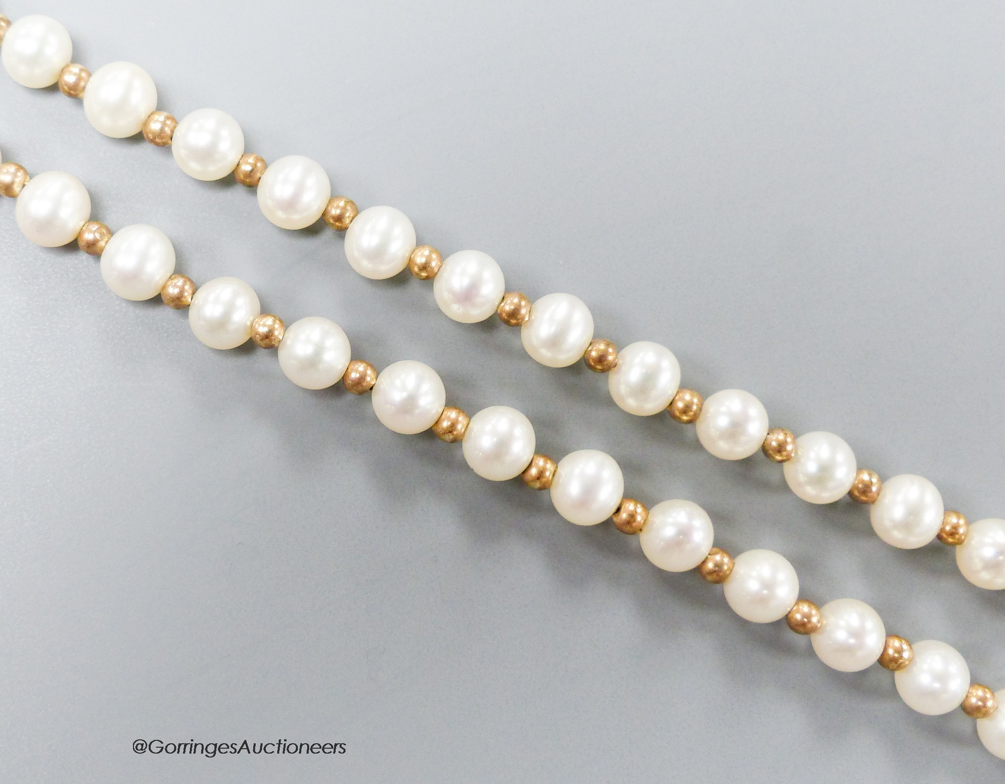 A modern single strand cultured pearl and yellow metal spacer set necklace, the clasp stamped 375, 39cm, gross weight 15.6 grams.